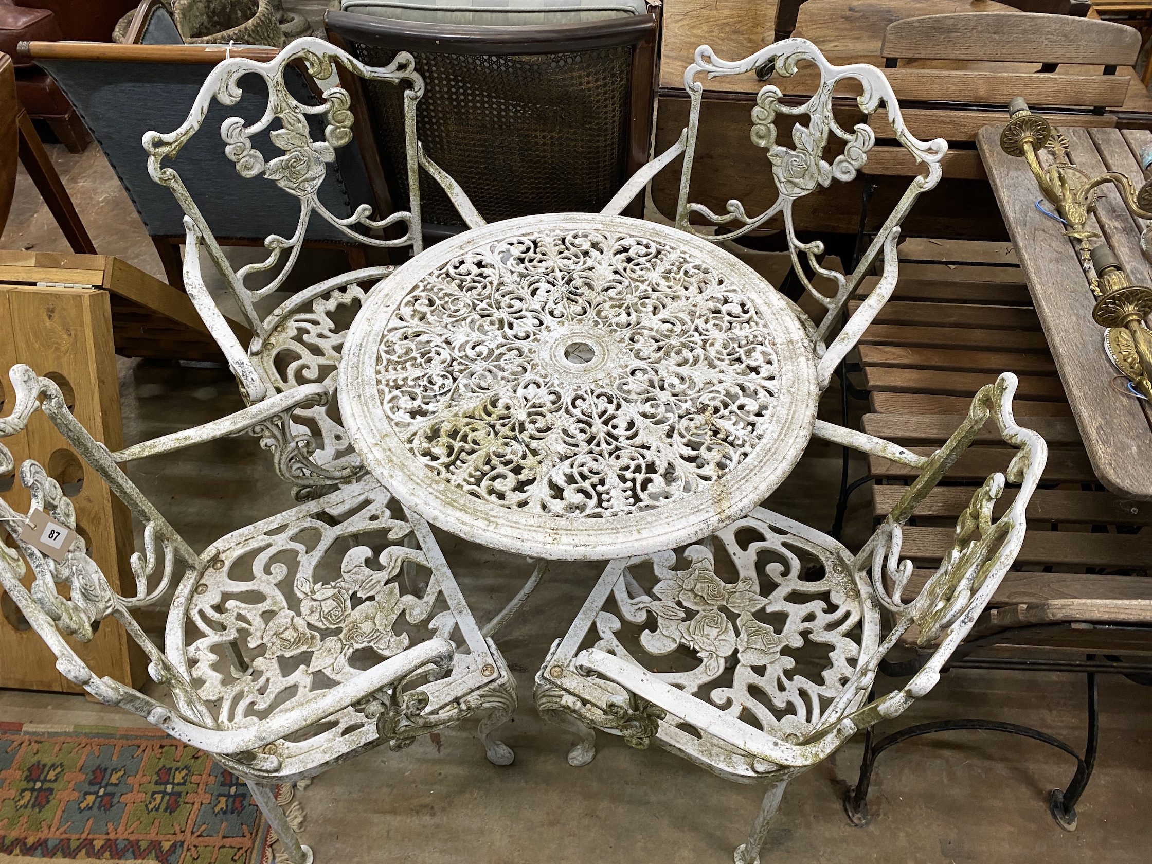 A painted aluminium circular garden table, diameter 68cm, height 68cm, together with four aluminium garden elbow chairs